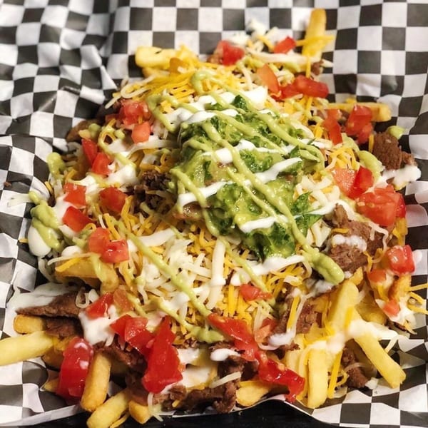 El Burro Loco's carne asada fries, topped with guacamole, sour cream, cheese, and diced tomatoes.