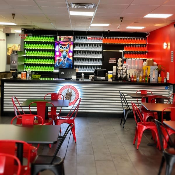El Burro Loco's vibrant interior features red chairs, black tables, and a counter with colorful bottled drinks.