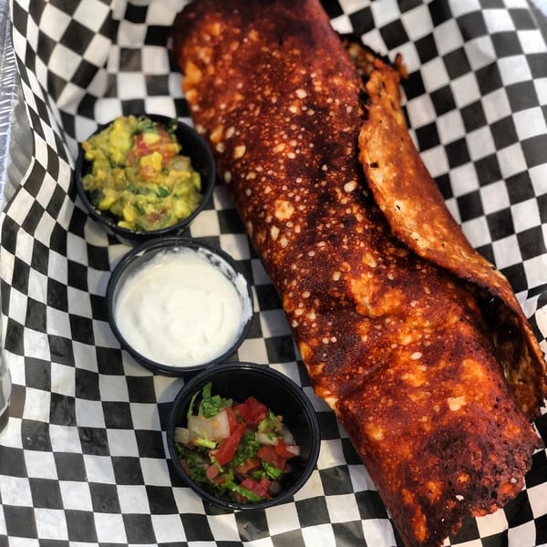 El Burro Loco's crispy burrito with sides of guacamole, sour cream, and pico de gallo.